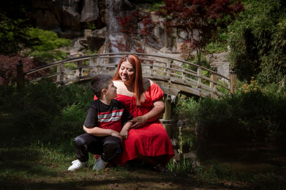 A peaceful moment captured on a wooden bridge in a lush garden setting.