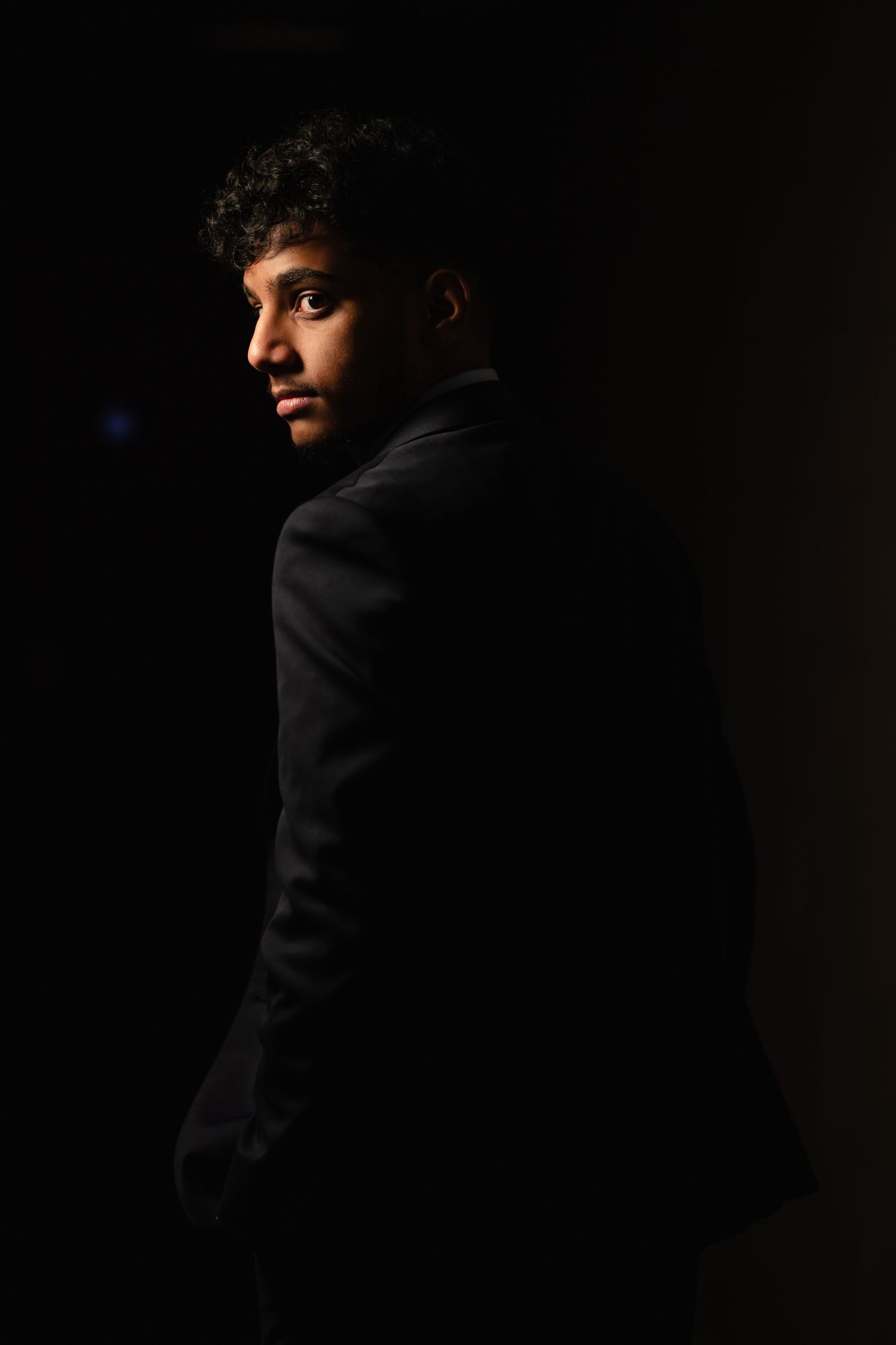 Dramatic black and white portrait series showing silhouettes against dark background.