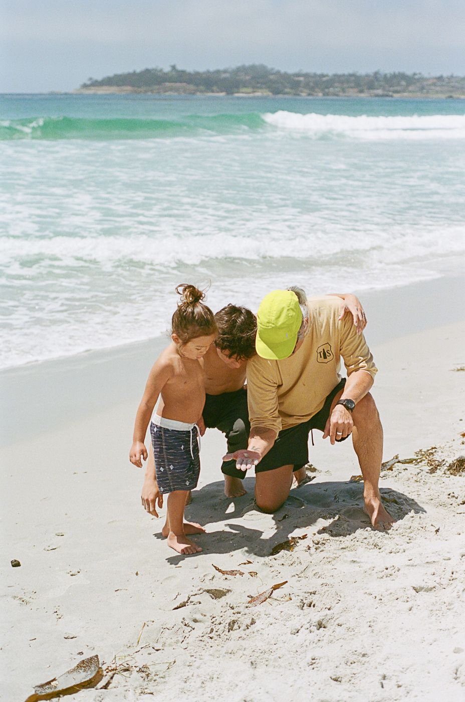 Group searching for seashells on the white sandy shoreline.
