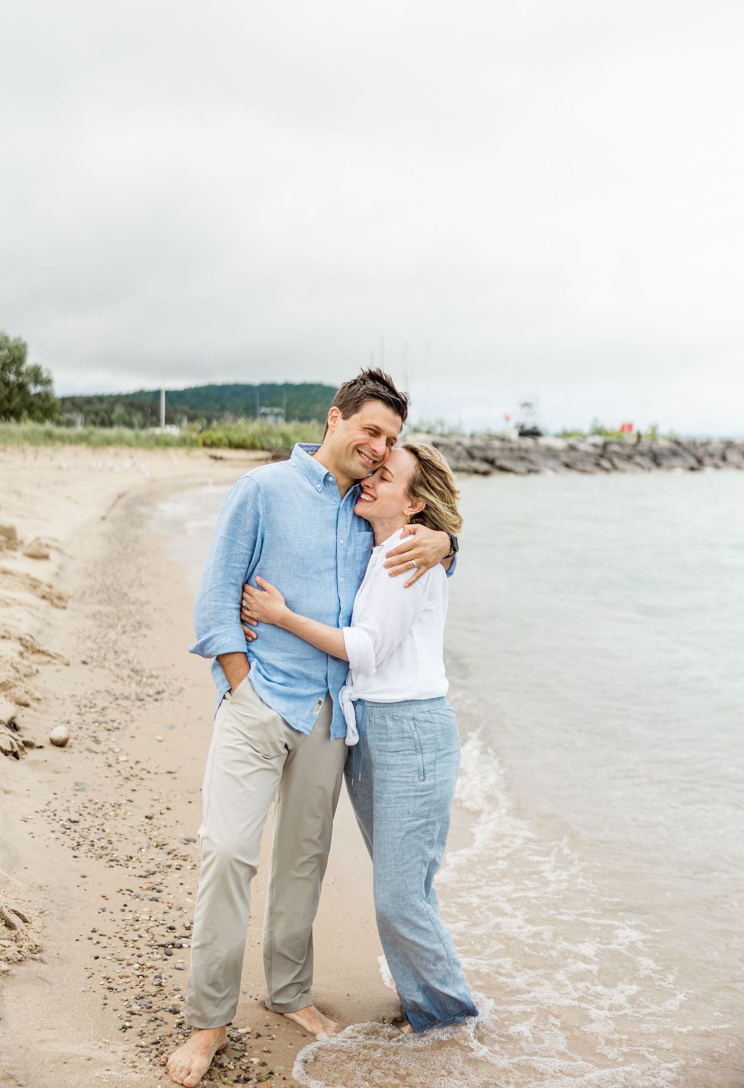 Couple parents embracing on North Beach in Leland, Michigan Captured By Grace Hudson Photography Traverse City