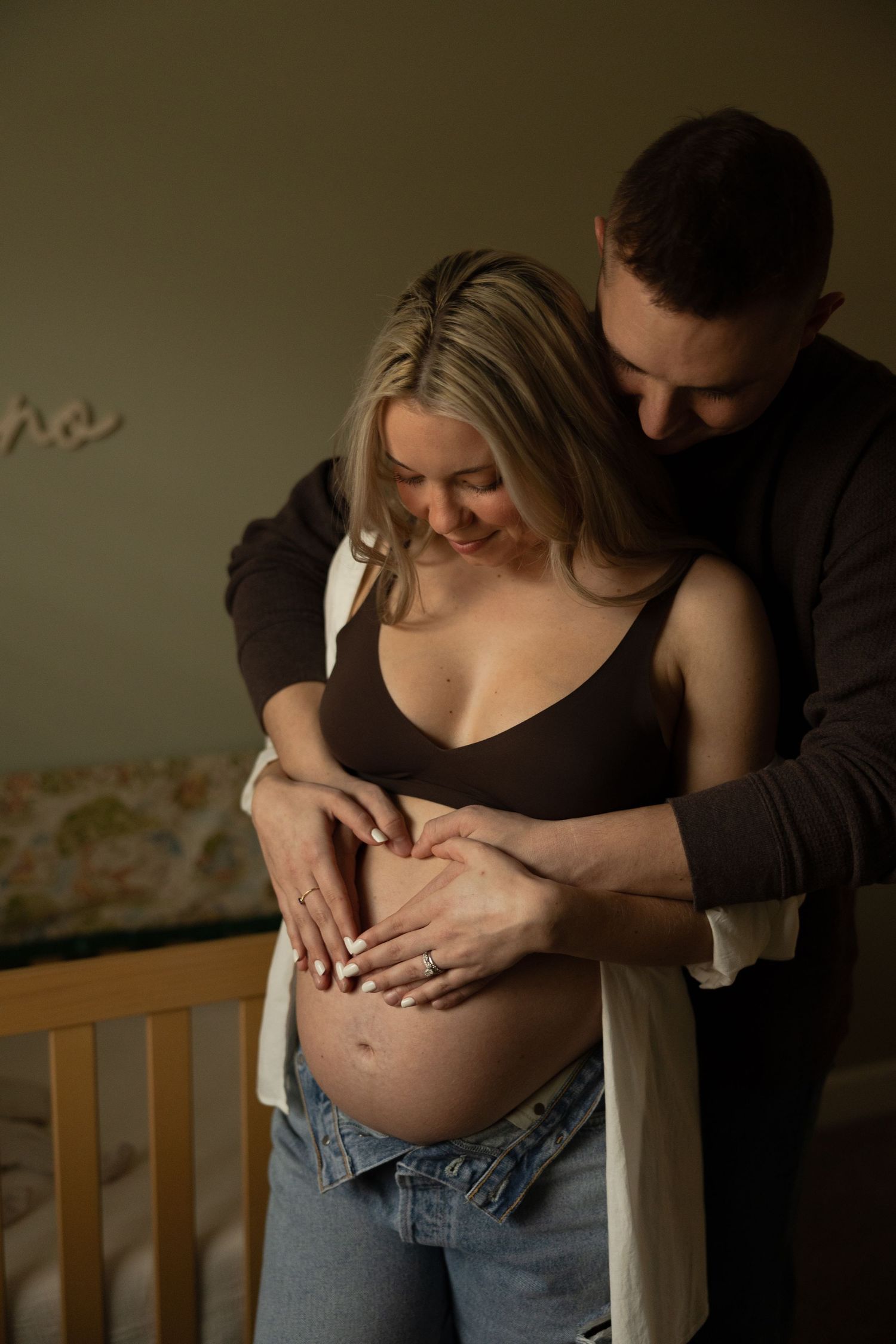 An intimate maternity photo of expectant parents sharing a tender moment.