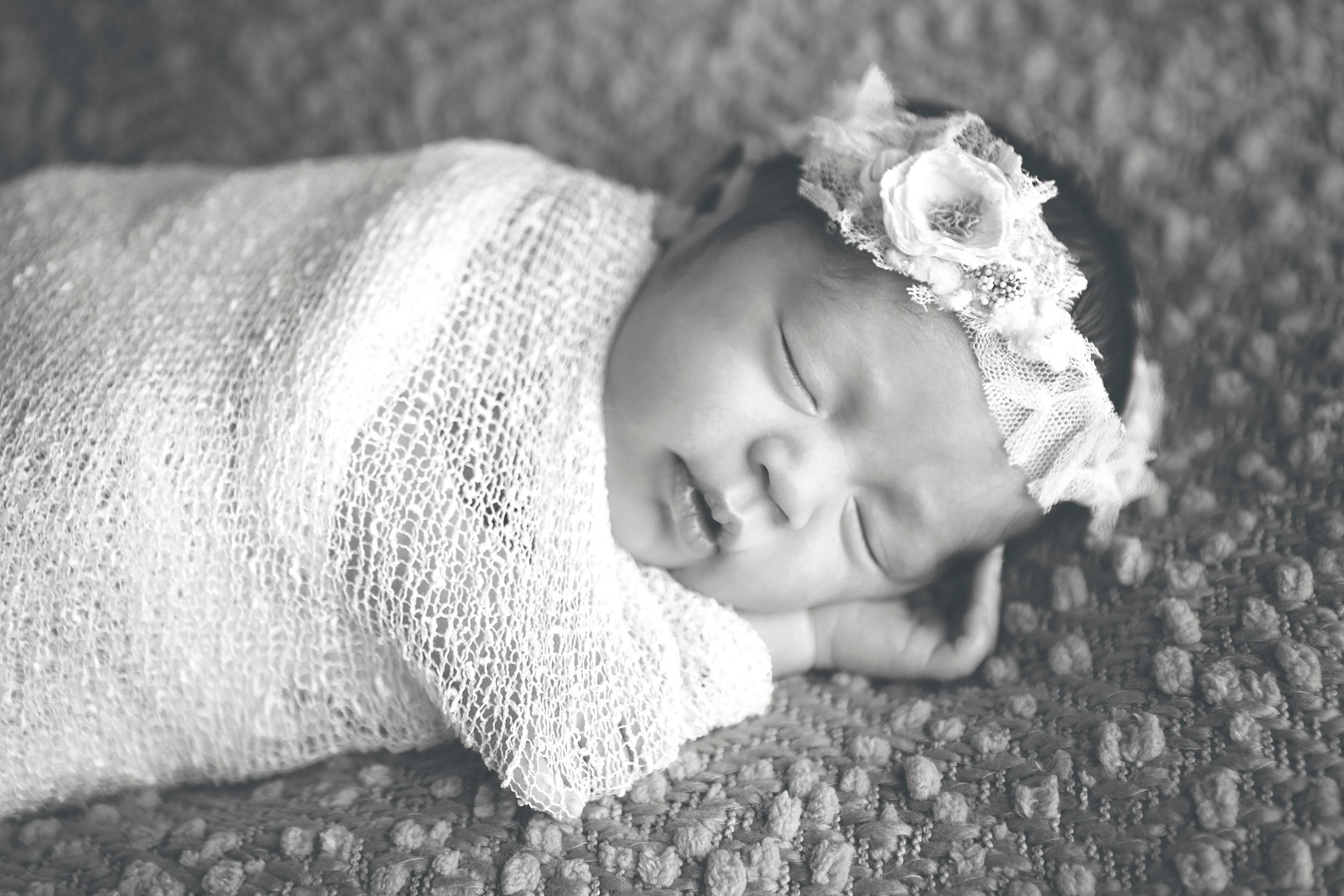 Classic black and white newborn portraits with soft white wrapping and delicate headpiece.