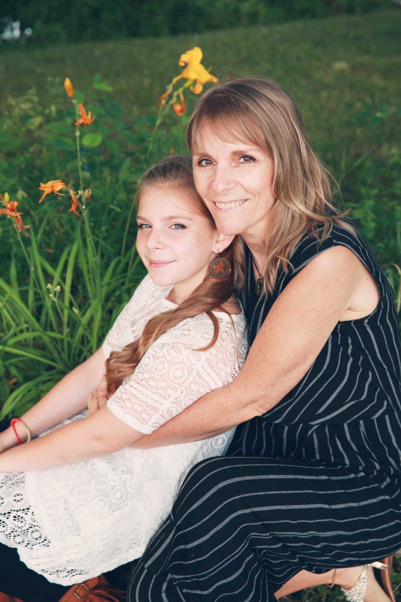 A heartwarming outdoor portrait with blooming orange daylilies in the background.