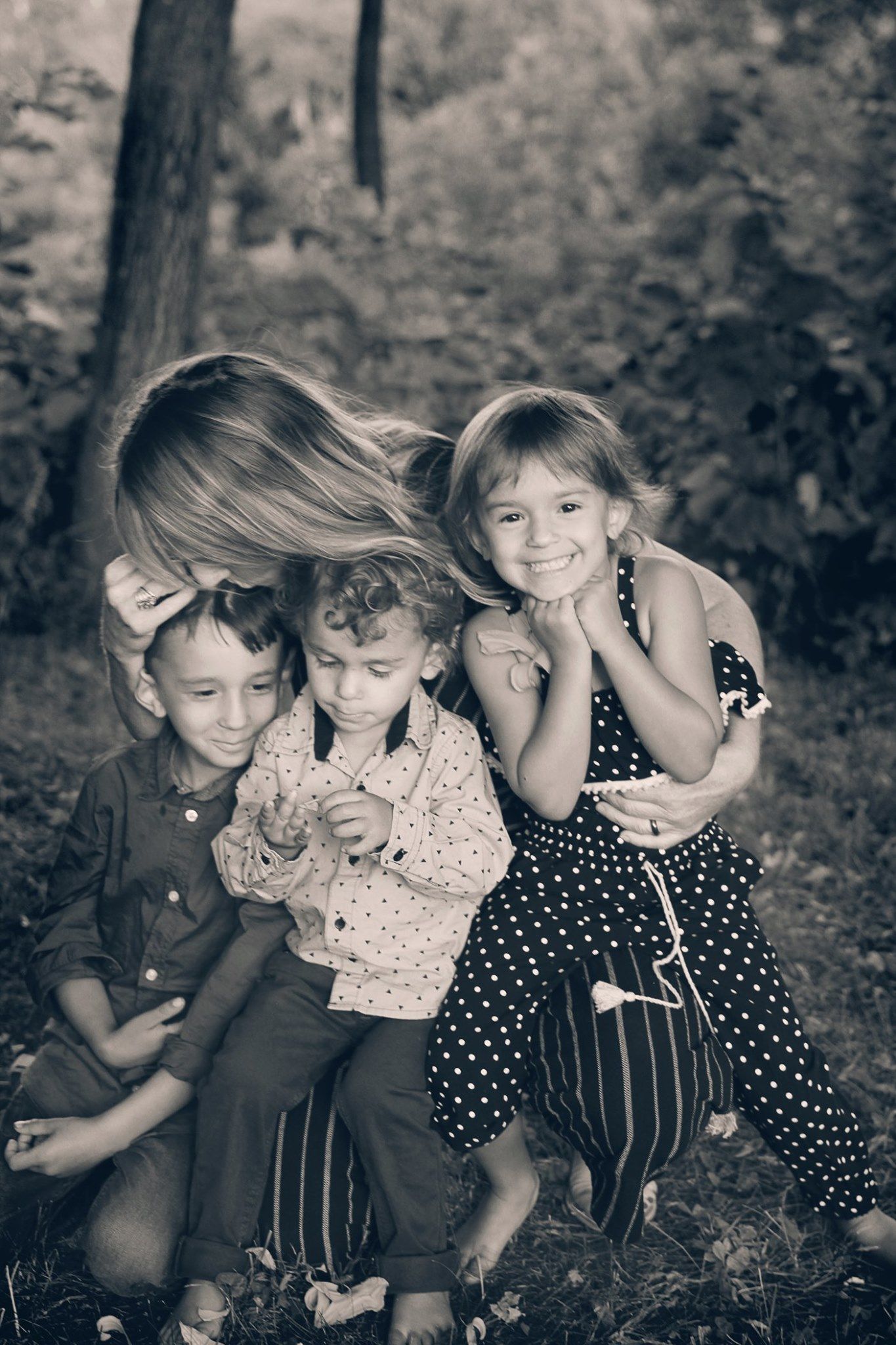 A black and white portrait of a playful group moment outdoors.