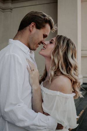 An engaged couple looking at each other, noses touching.