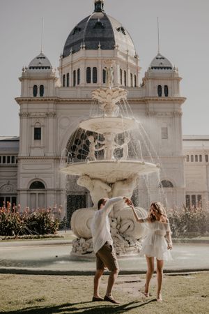 A couple dancing infront of a fountain.