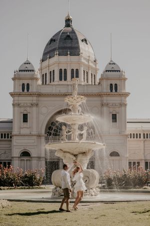 A couple dancing infront of a fountain.