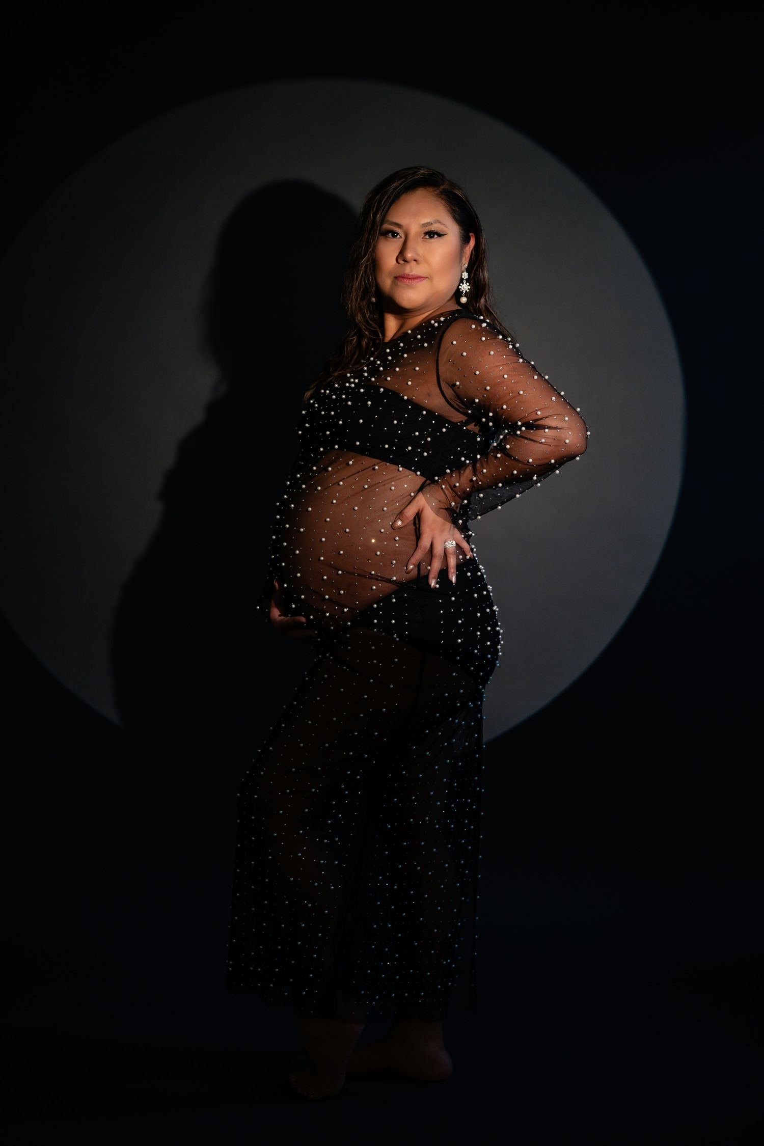Glamour portraits in sparkly black dress with dramatic spotlight effect.
