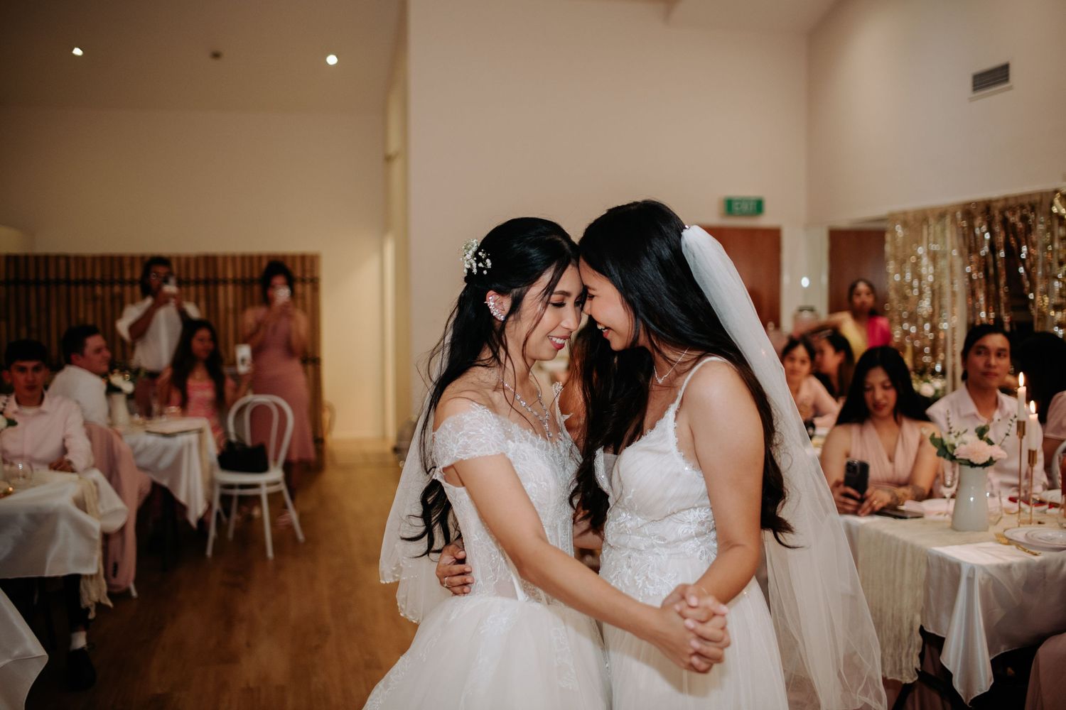 Two brides sharing an intimate dance moment at their wedding reception.