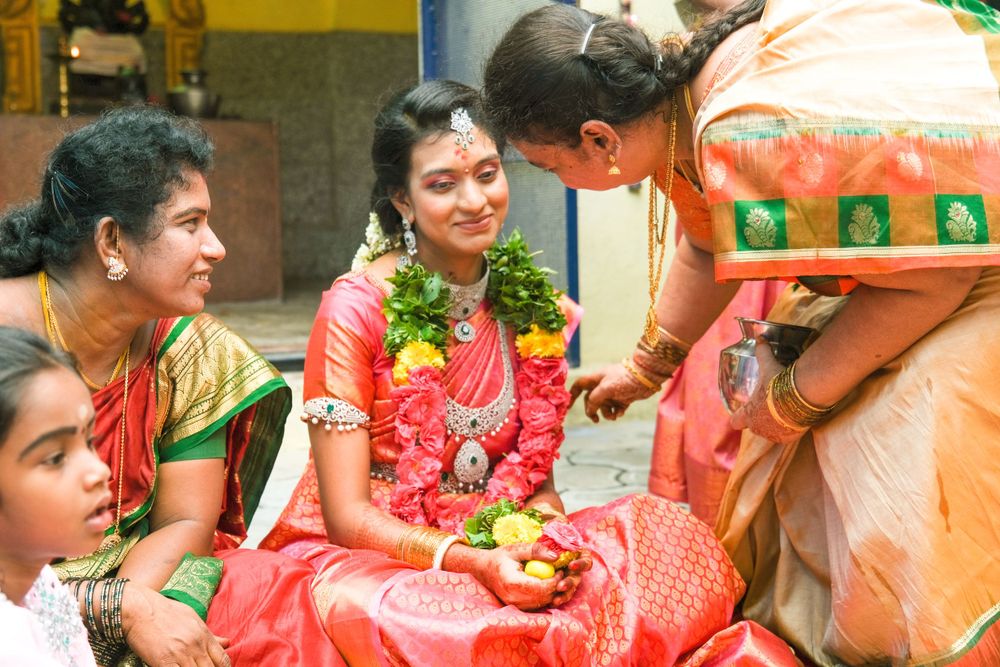 Ritual gathering with women in bright saris seated on floor during ceremony.