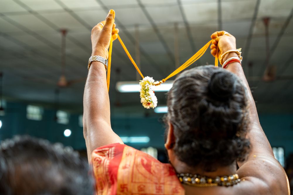 Close-up of hands holding ceremonial decorations during traditional ritual.
