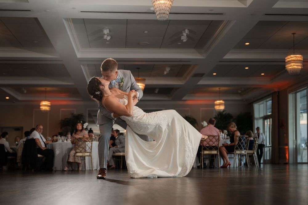 Romantic dip dance move during a wedding reception on indoor dance floor.