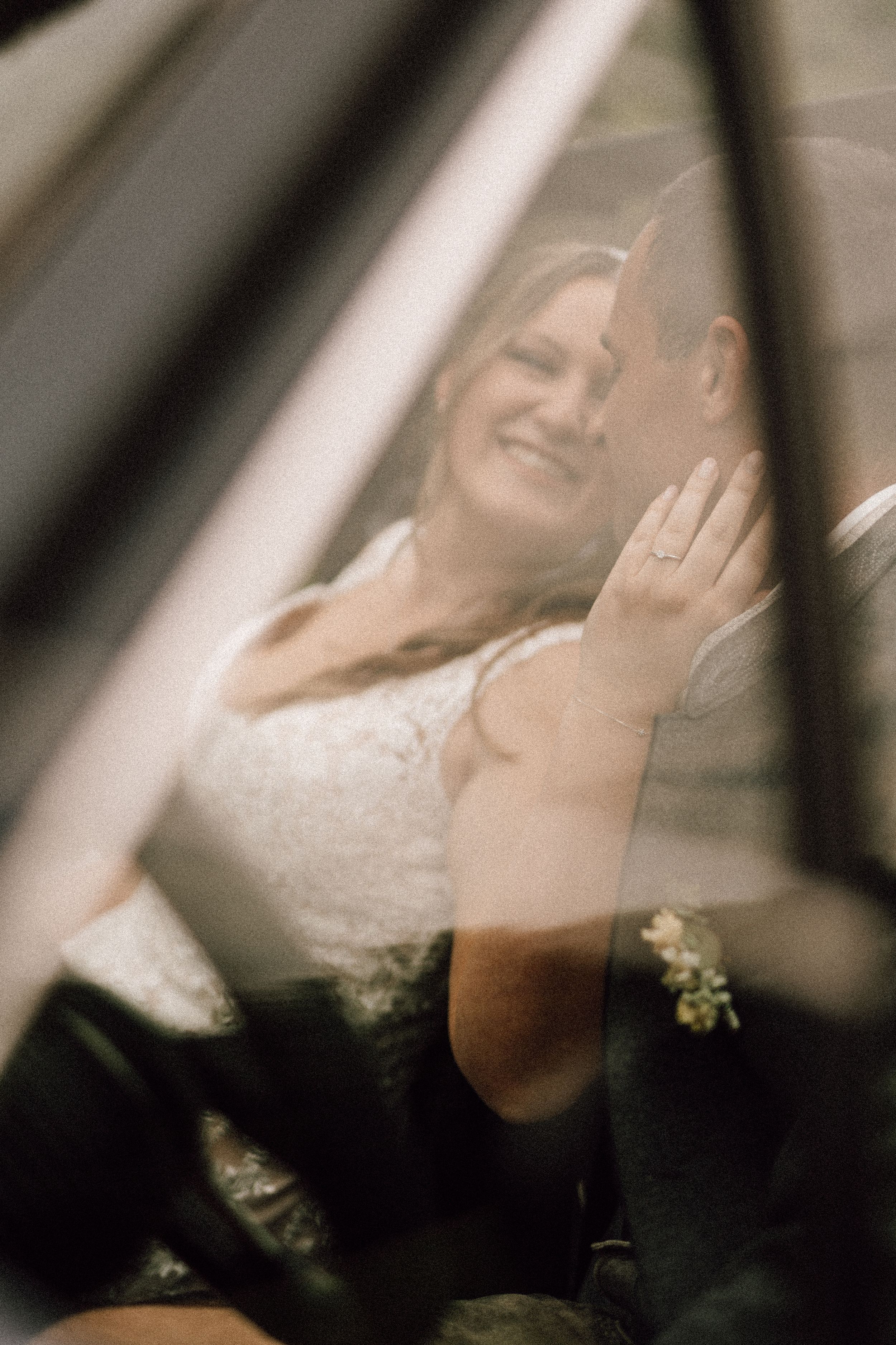 Dreamy, filtered wedding photo taken through car window glass creating a romantic effect.