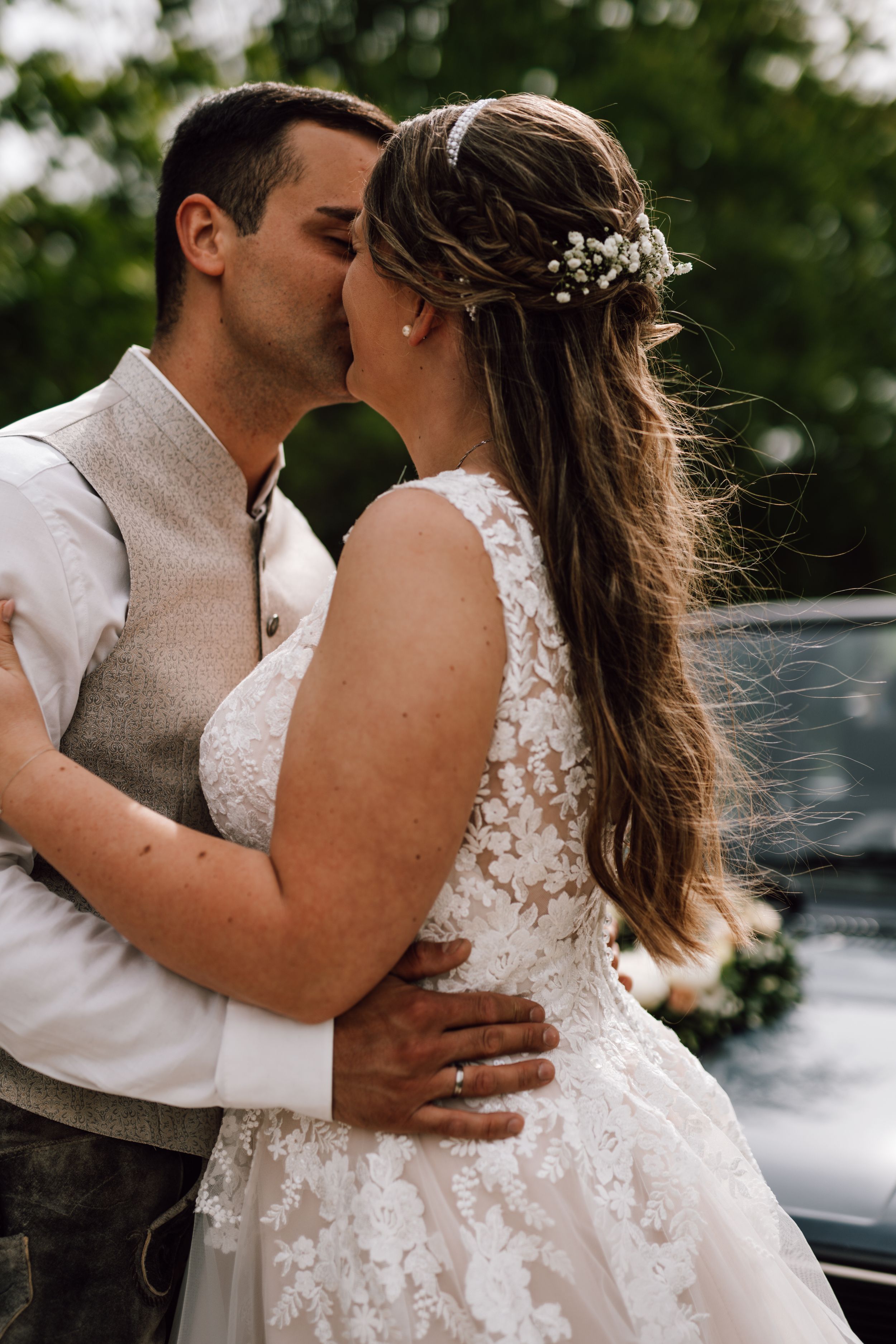 Tender wedding moments captured in a sequence of romantic embraces outdoors.