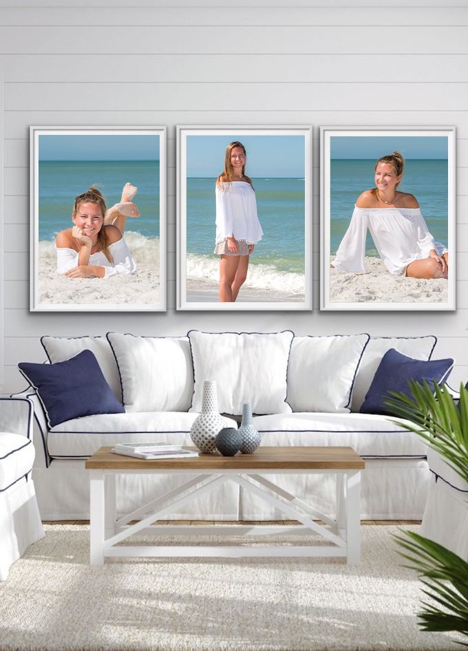 Three framed beach photos of a young woman in white displayed above a coastal living room sofa.