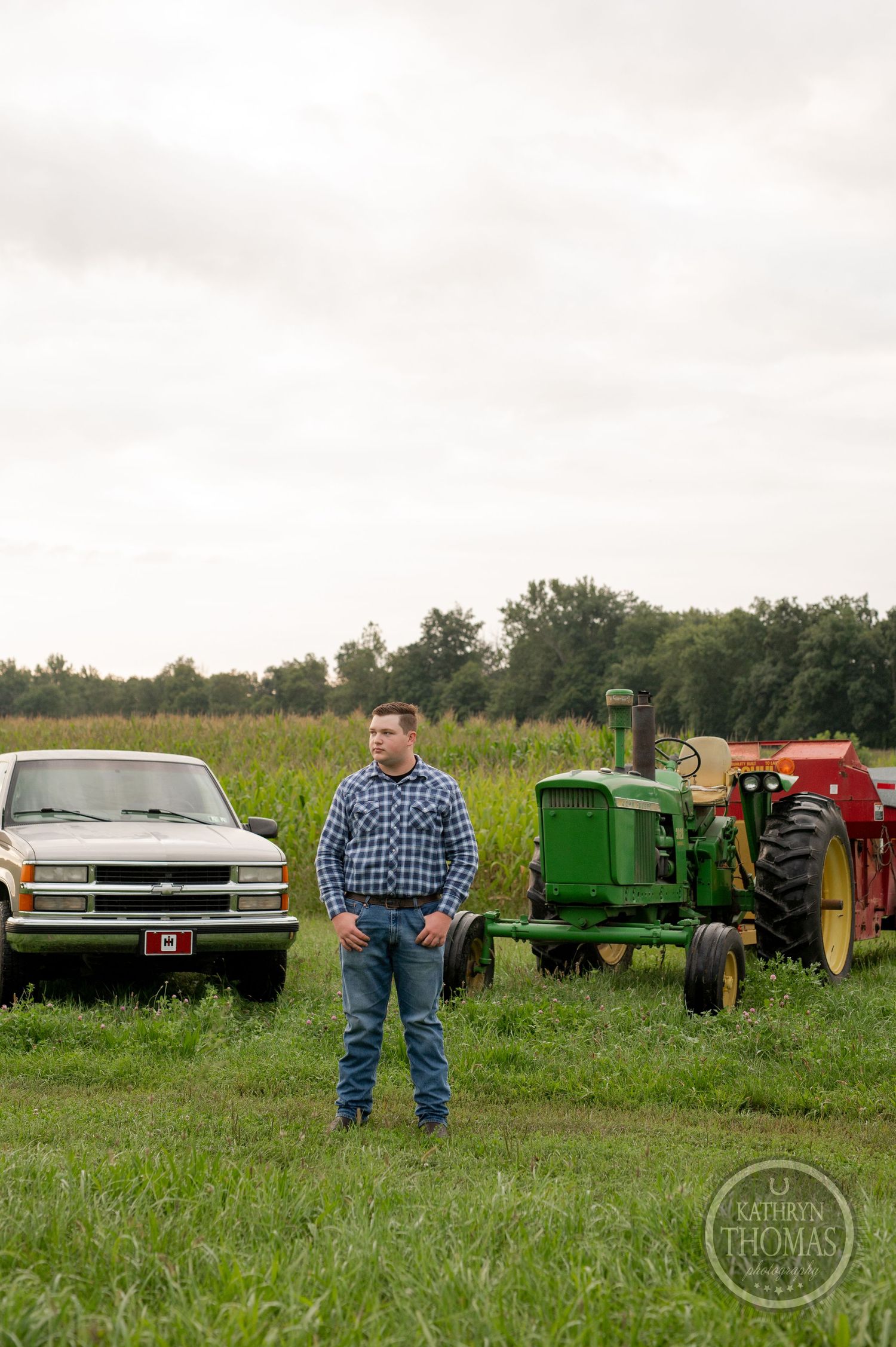 Classic Chevrolet pickup truck and vintage John Deere tractor in a rural field setting.