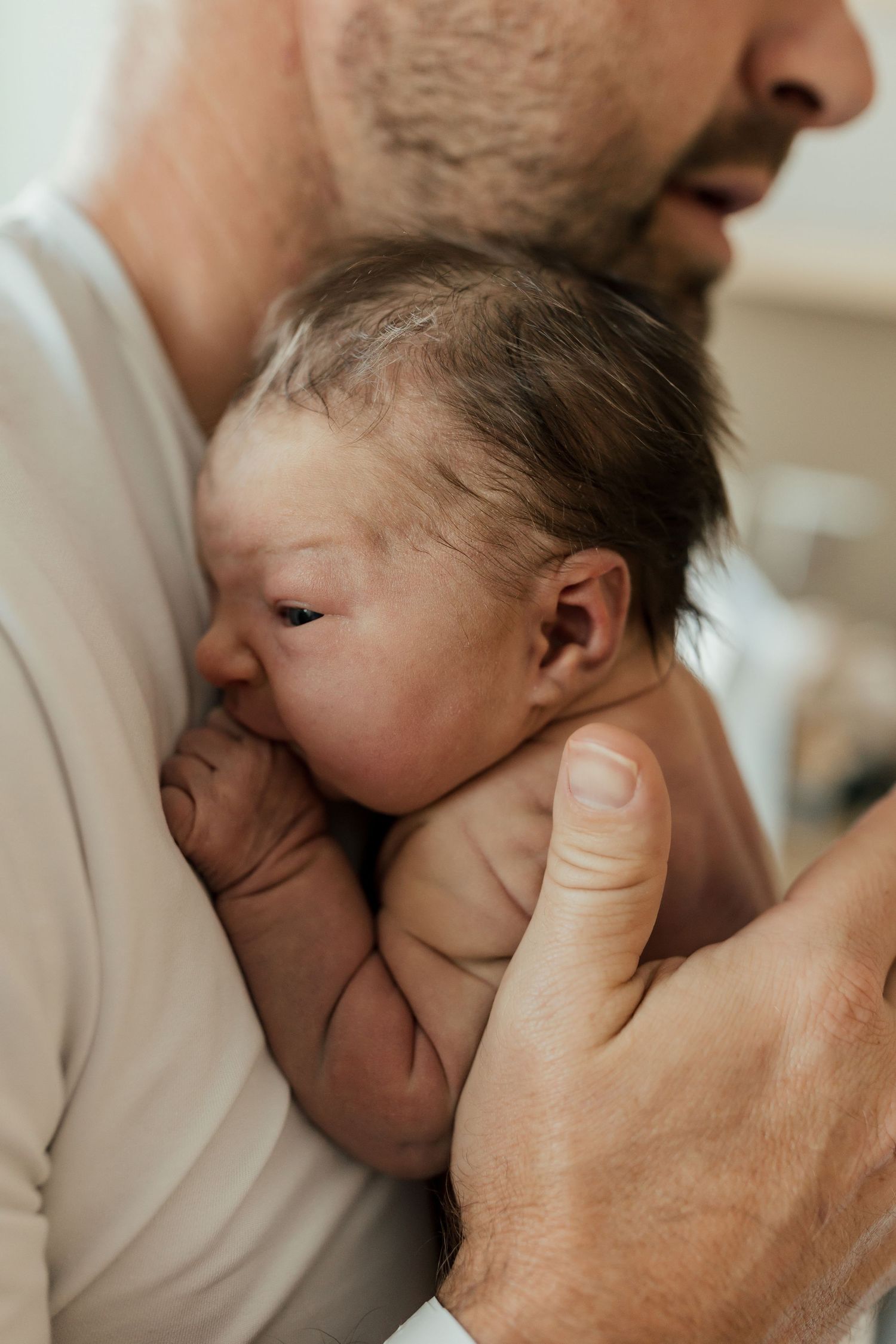 A tender moment showing a newborn baby being gently cradled and kissed in a series of intimate close-up shots.