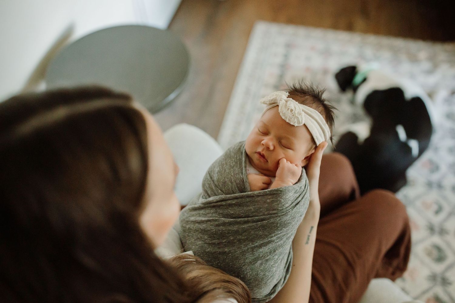 Baby wrapped in gray blanket sleeping peacefully on soft surface.
