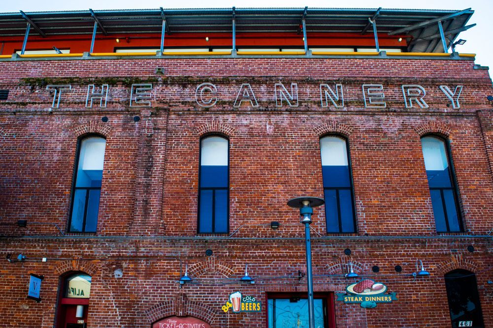 Old brick building with Cannery signage and blue-trimmed windows in historic architecture style.
