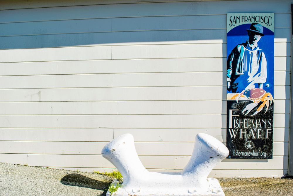 White painted wall with vintage-style advertisement sign and nautical decorations.