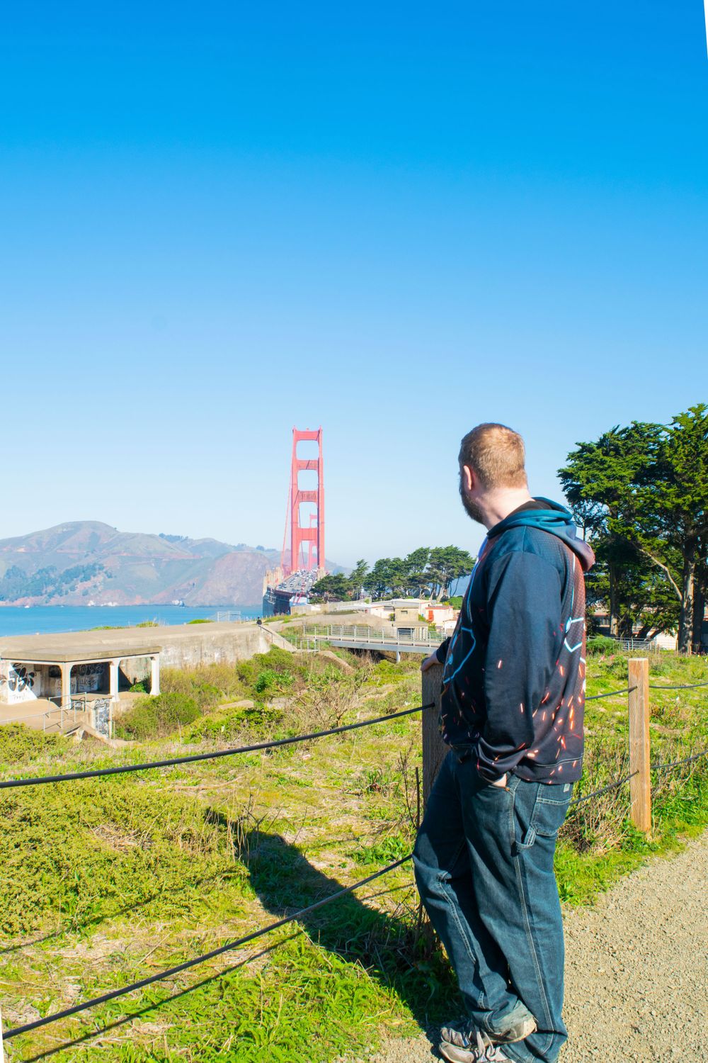 View of the Golden Gate Bridge from a hiking trail with scenic bay views.