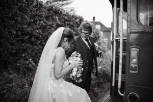 Black and white wedding photos showing a couple entering a vintage bus on their special day.