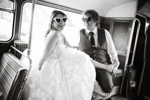 Wedding party celebrating inside a retro bus with joyful expressions and candid moments.