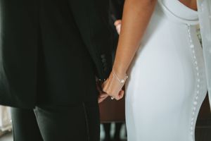 Elegant wedding dress details showing fitted silhouette against dark background.