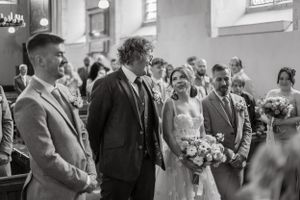 Black and white photos of wedding guests mingling in a church setting.