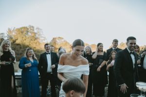 Wedding guests lined up outdoors against blue sky during daytime celebration.