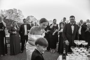 Elegant wedding reception guests gather around champagne glasses at an outdoor celebration.