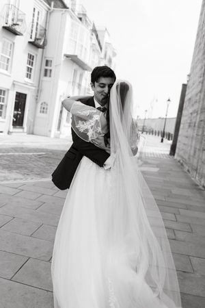 Romantic black and white portraits of newlyweds dancing outdoors.
