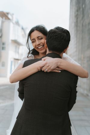 Candid wedding photos capturing emotional embraces between couple.