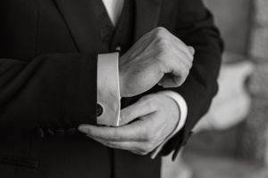 Close-up black and white photo of hands exchanging wedding rings during a ceremony.