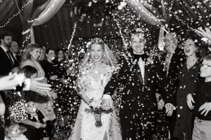 Wedding party celebration with confetti and champagne spraying in black and white.