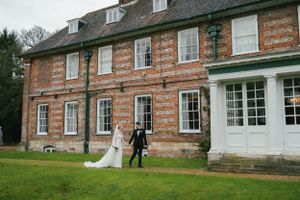 Rustic brick wedding venue exterior with traditional architecture and landscaping.