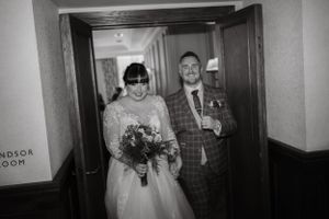 Black and white wedding photos in a dimly lit hallway.