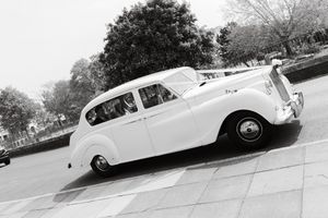 Vintage white luxury car captured at an angle in monochrome photography.