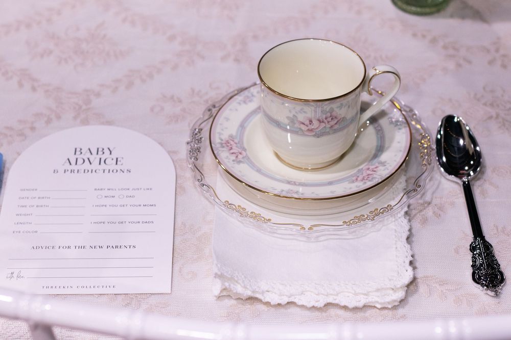 Elegant pink and gold wedding place settings with delicate lace details and vintage teacups on a light tablecloth.