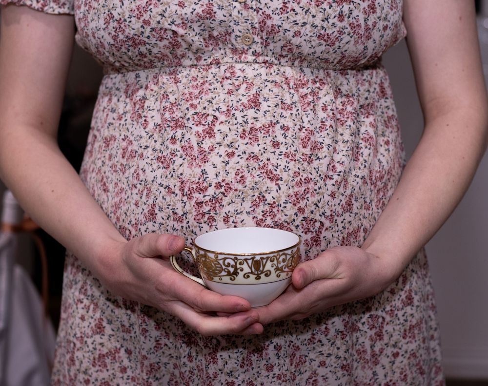Close-up series showing hands holding a white ceramic bowl against a pink floral dress pattern at a baby shower