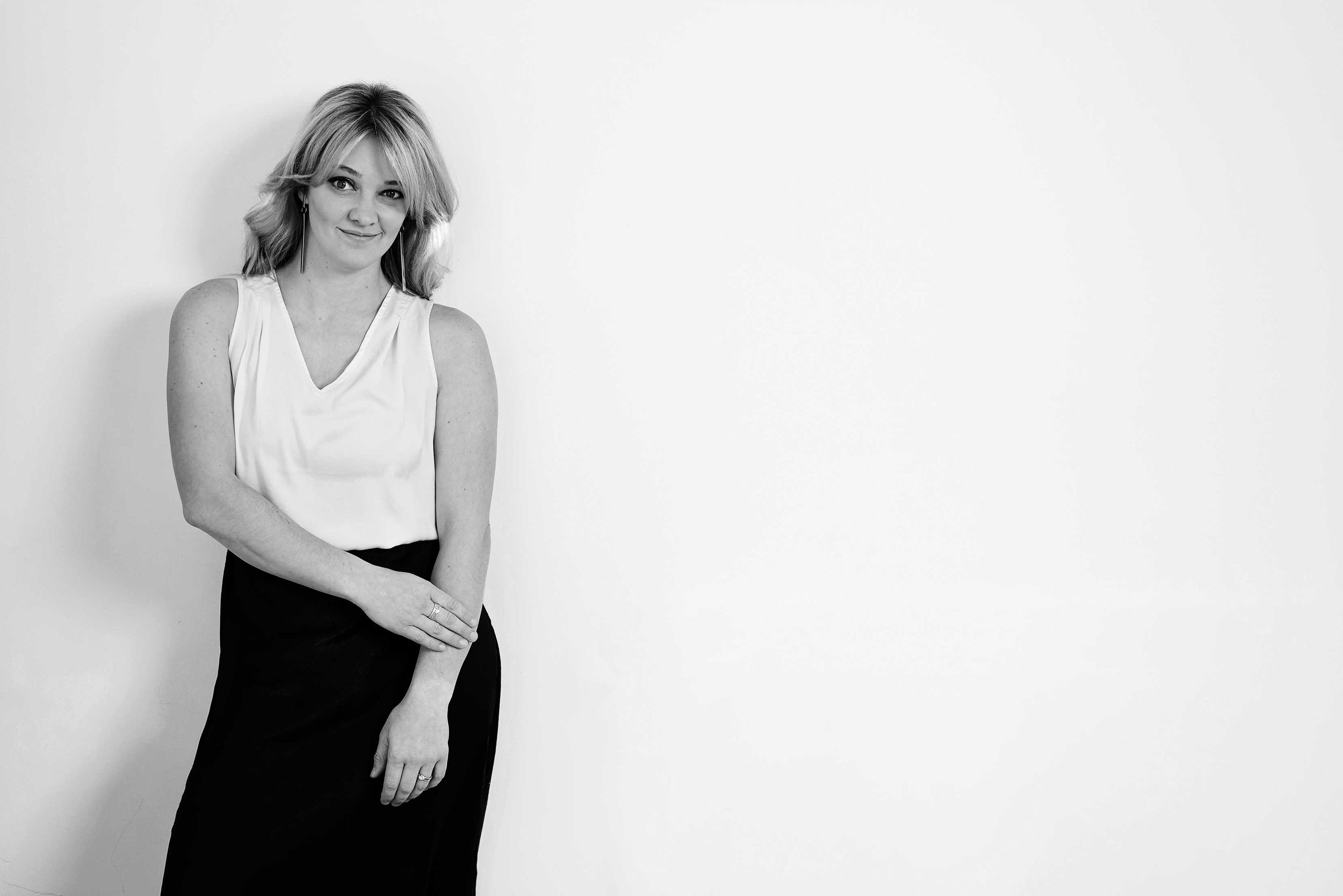Minimalist black and white portrait against a white studio backdrop.