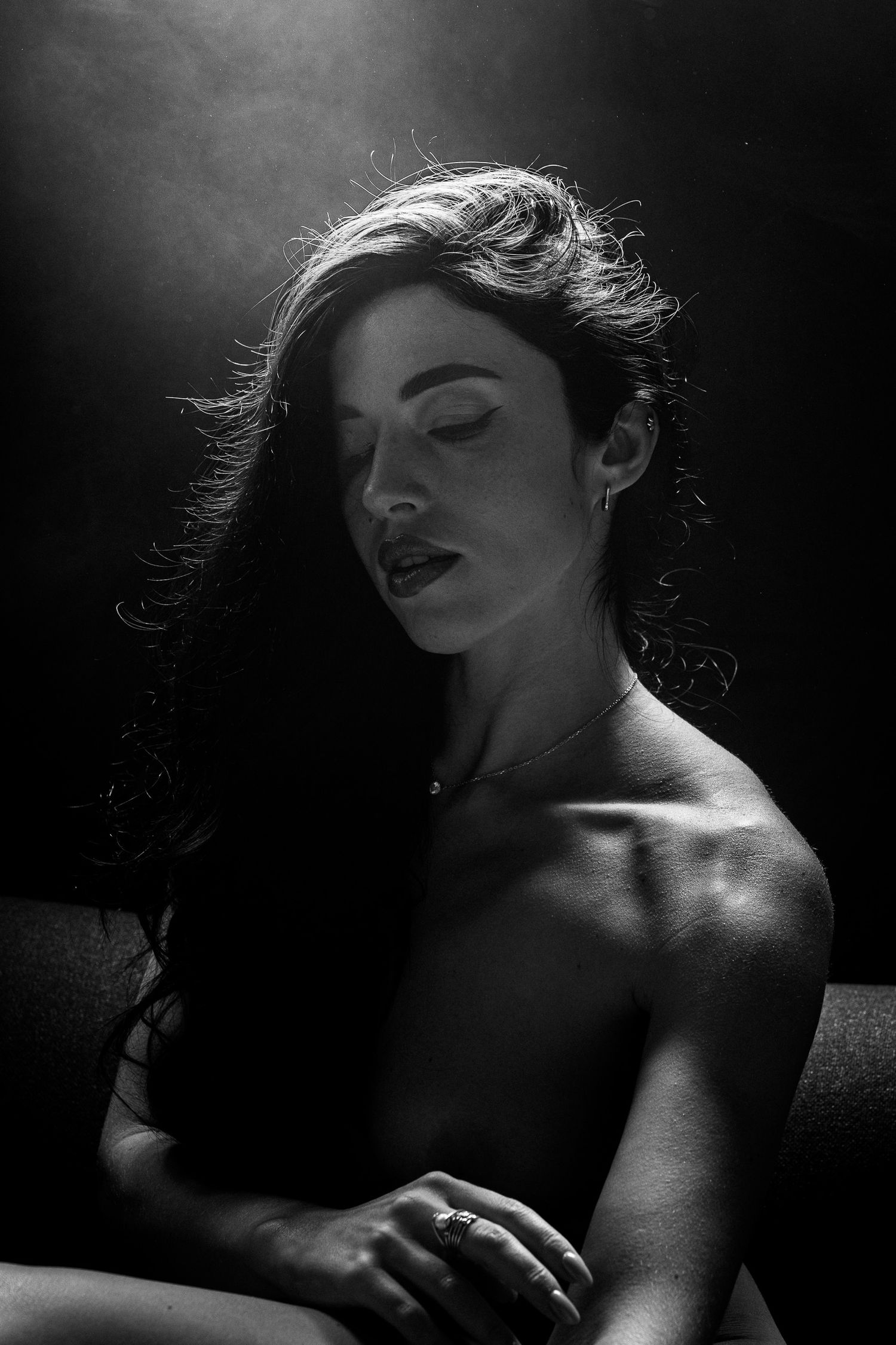 Black and white portrait of a young woman with long dark hair in dramatic lighting.