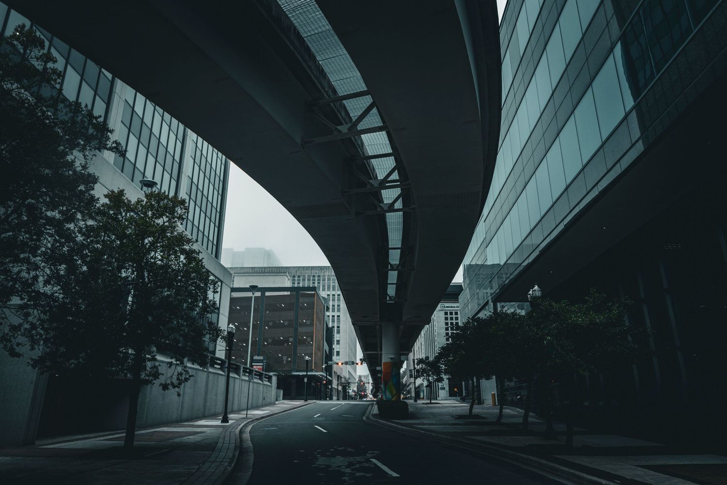 Modern urban architecture with curved overpass creating dramatic shadows.