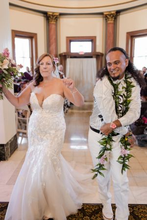 Bride and groom dancing down the aisle with their hands in the air after being pronounce husband and wife.