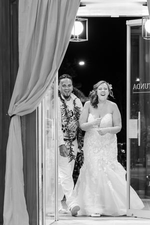 Bride and groom walking in the door excitedly for their grand march.