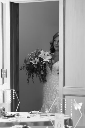 Bride peeking out of the door for the first time just before she meets her father to walk down the aisle.