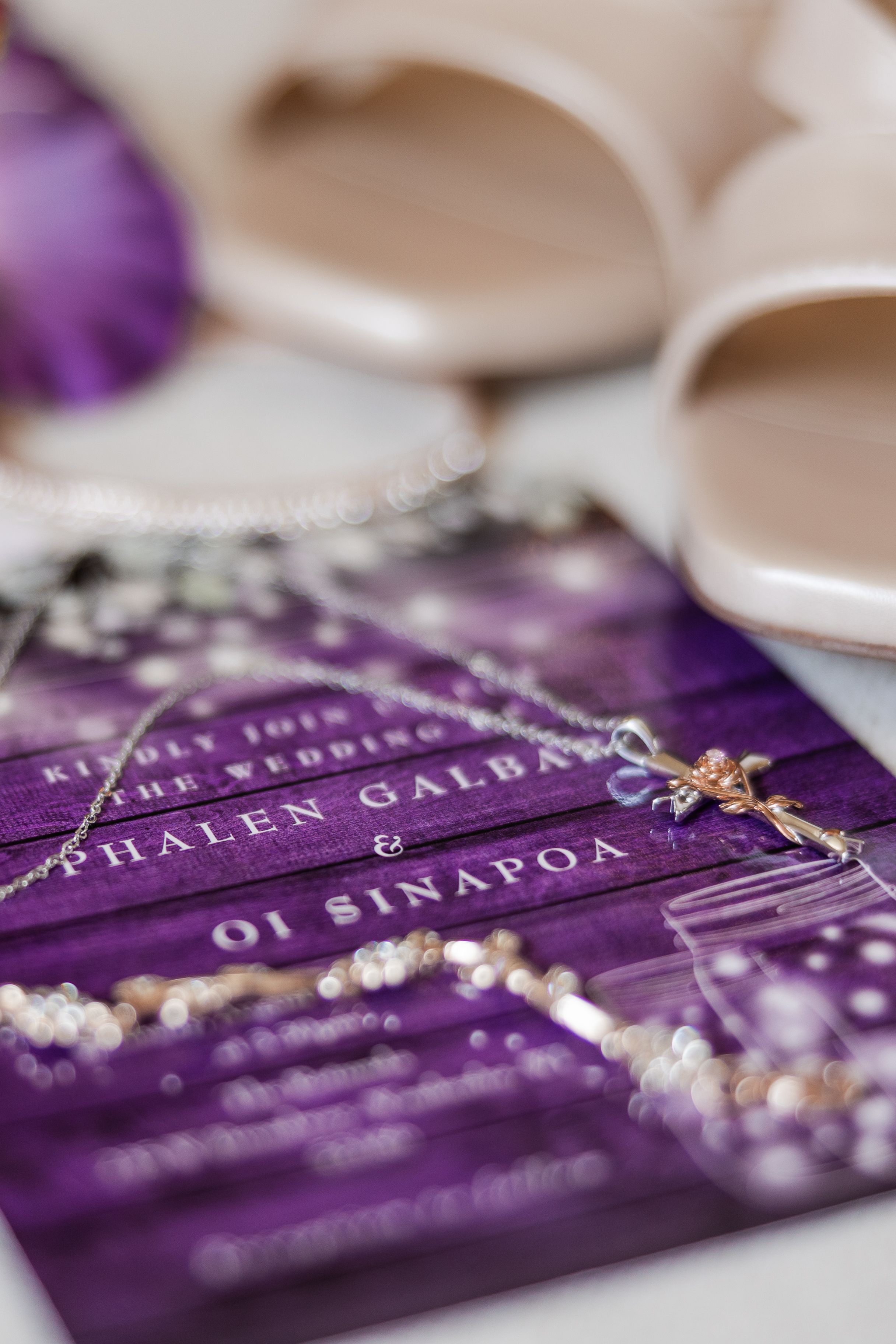Wedding invitation laid out with jewelry and shoes the bride will be wearing on her wedding day.