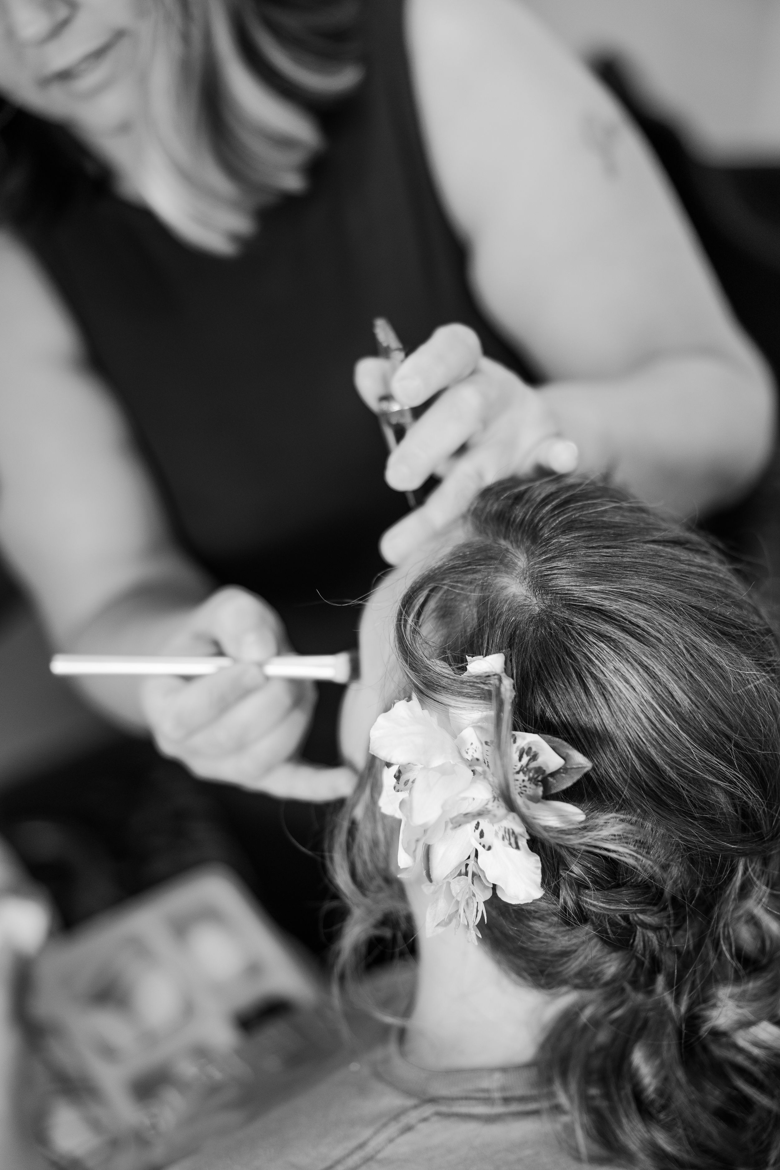 Make-up artist applying the brides make-up in black and white.