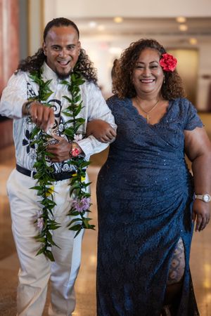 Groom walking down the aisle pointing at the camera smiling big and showing his personality.