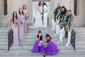 Bride and groom kissing in front their bridal party. The flower girls are covering their eyes embarrassingly.